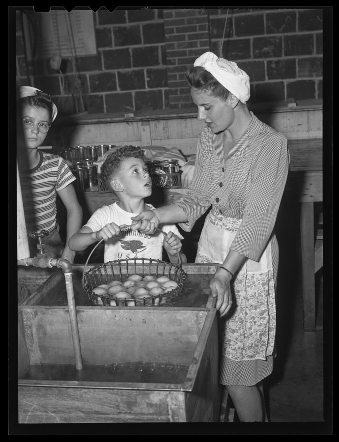 1945-09-10 Woman and children with potatoes at the Community Canning Kitchen