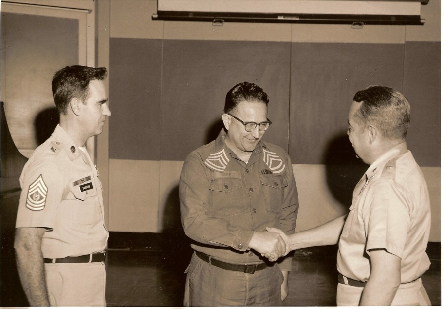 US Army Sgt. 1st Class Steele, center, shaking hands with a General