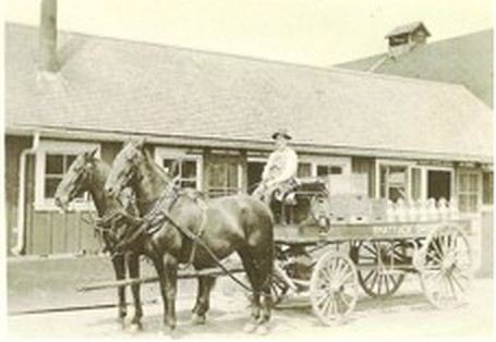 Peter Gertsch driving a dairy wagon