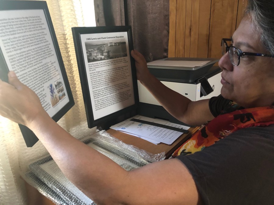 Susan Houseman framing the placards describing the photos and train reliefs from Lamb’s Thriftway - 2020