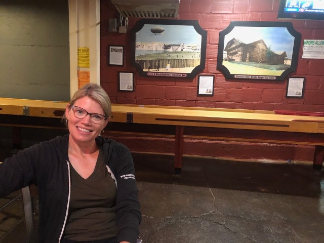Shelly Bigley in front of the Lewis and Clark Centennial photos at the Old Market Pub